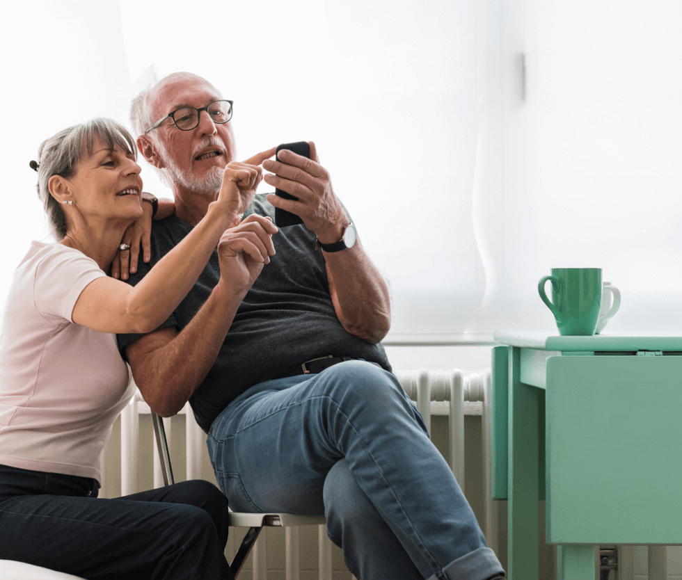 Senior couple using a phone at home