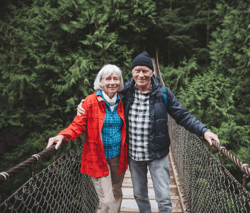 Older couple standing on rope bridge